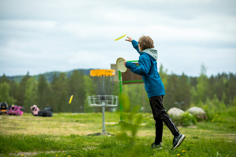 Lapsi heittämässä frisbeegolfia