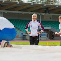 Valmentaja katsomassa lapsia urheilukentällä